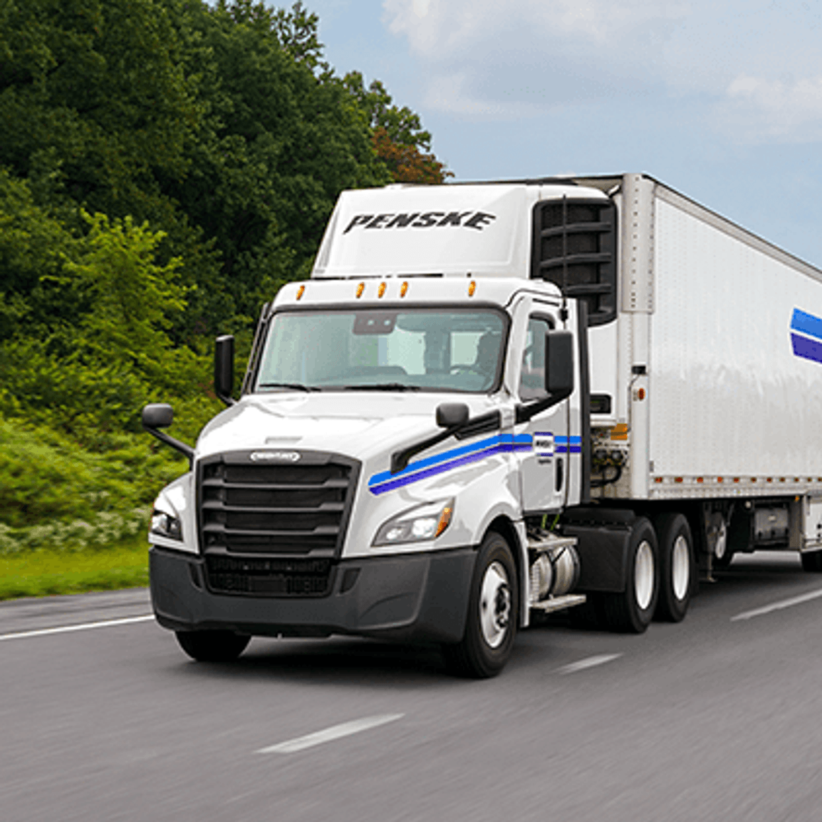 White Penske truck on a tree-lined highway