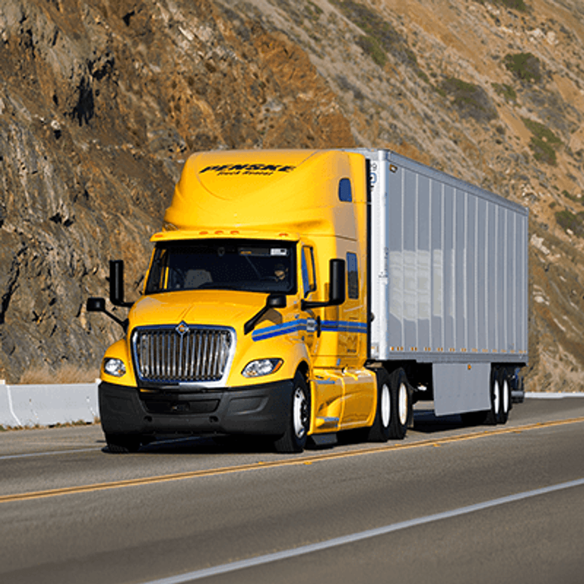 Yellow Penske tractor trailer on the road