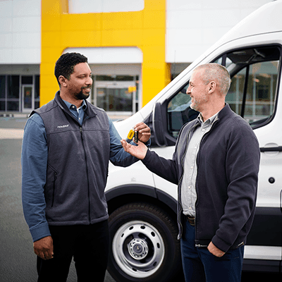 Penske rep handing truck keys to a customer