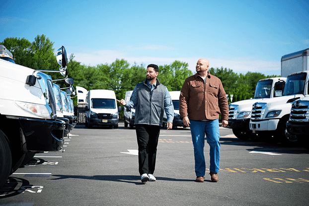 Customer and sales rep looking at trucks on a lot