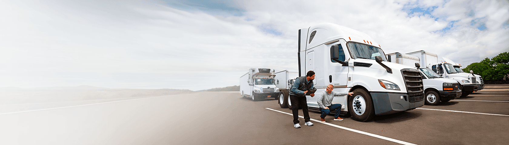 Two people in front of trucks